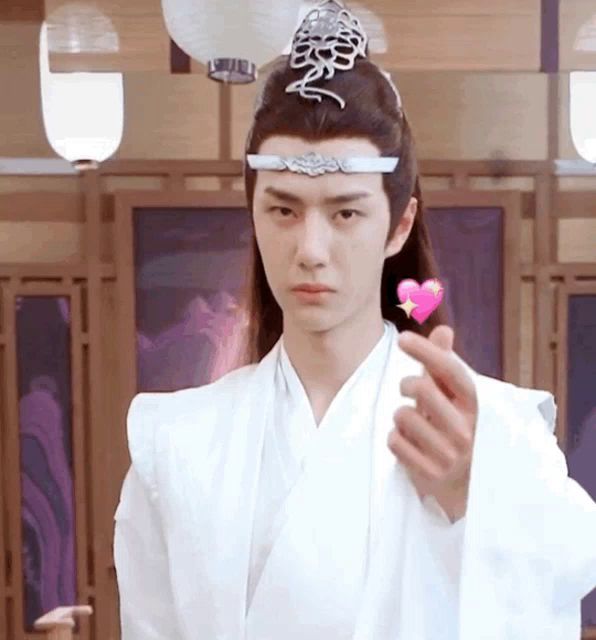 a man in a white kimono is holding a heart in his hand