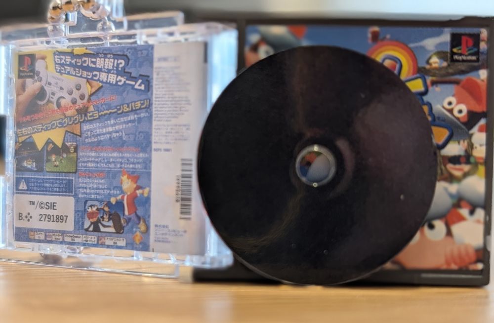 A miniature PS1 game and case as a keychain from a gachapon machine. This is a recreation of the Japanese version of Ape Escape. The rear case art and back of the disc are shown here.