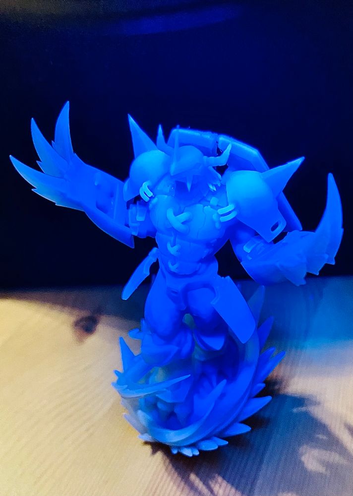 A close up shot of a Wargreymon 3d printed figure under a UV light
