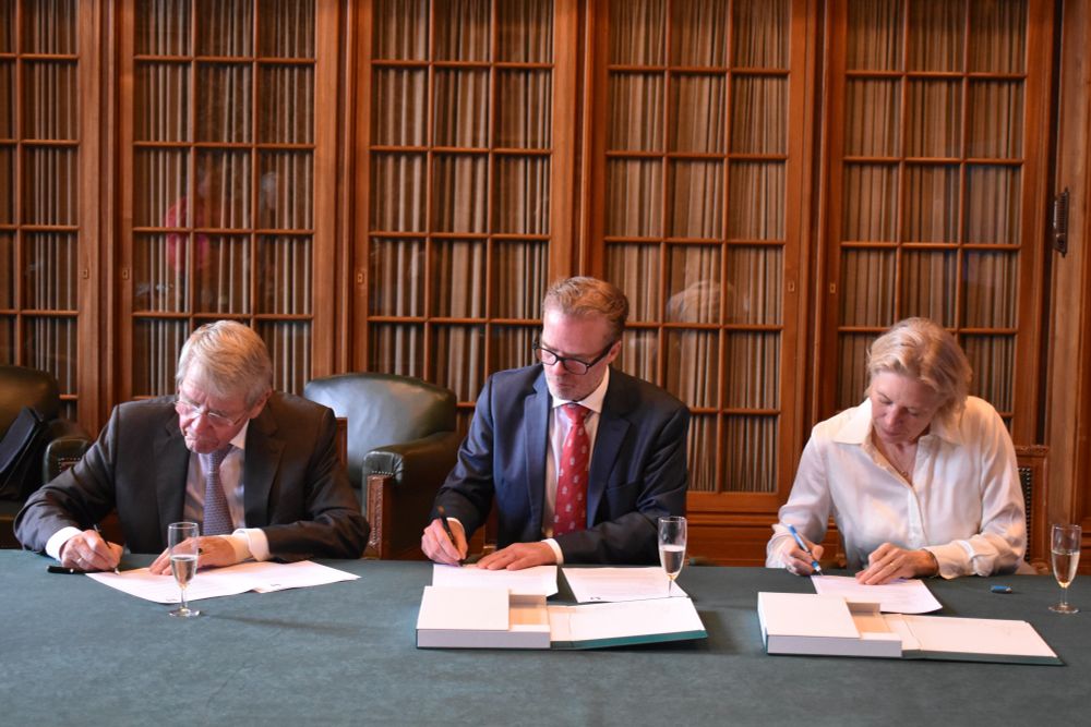 Picture showing (from left to right) Piet Hein Donner, Maurits van den Boogert and Anniek Meinders each signing a contract.