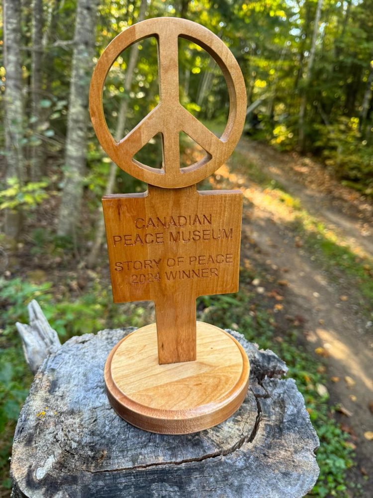 A wooden trophy featuring the CND peace symbol