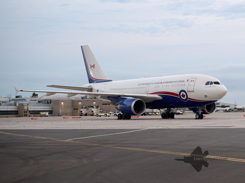 CC-150 Polaris 15001 rests at London International Airport in overcast conditions. The background features a hangar and various facilities found at the airport. 