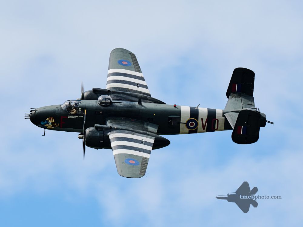 A B-25J Mitchell named "Hot Gen" makes a top side pass at CFB Trenton. This B-25J has the D-Day invasion stripes painted on it, and features machine guns on the nose as well as on the tail of the body. 