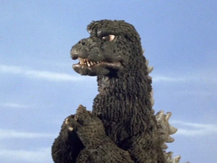 Godzilla crossing his fingers, surely pondering something important