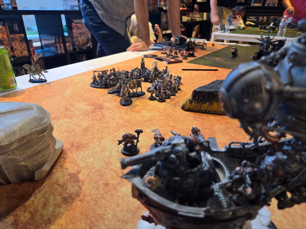 Over the should shot of a dwarf in a Cannon ready to fire at some foot soldiers.