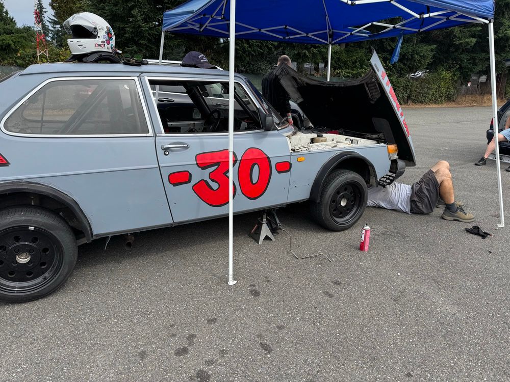 A man is seen working underneath the worlds cutest race car