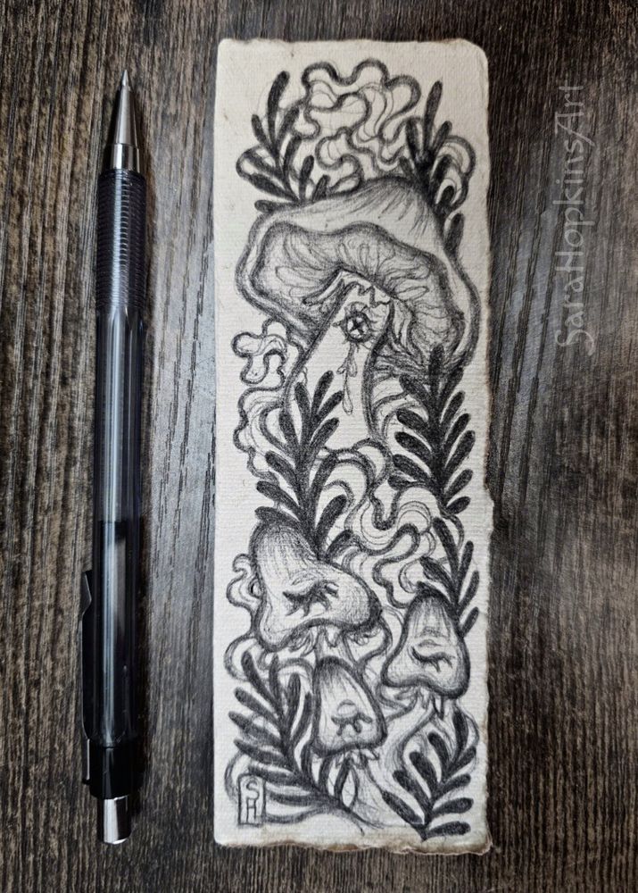 Handdrawn ballpoint pen ink illustration of surreal mushrooms on a handmade cotton paper bookmark 