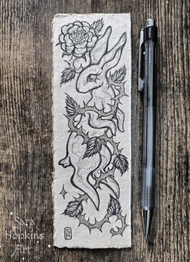 Black and gold Ink drawing on handmade cotton paper bookmark. Illustration shows bunny rabbit with rose thorn vine wrapping around it. 