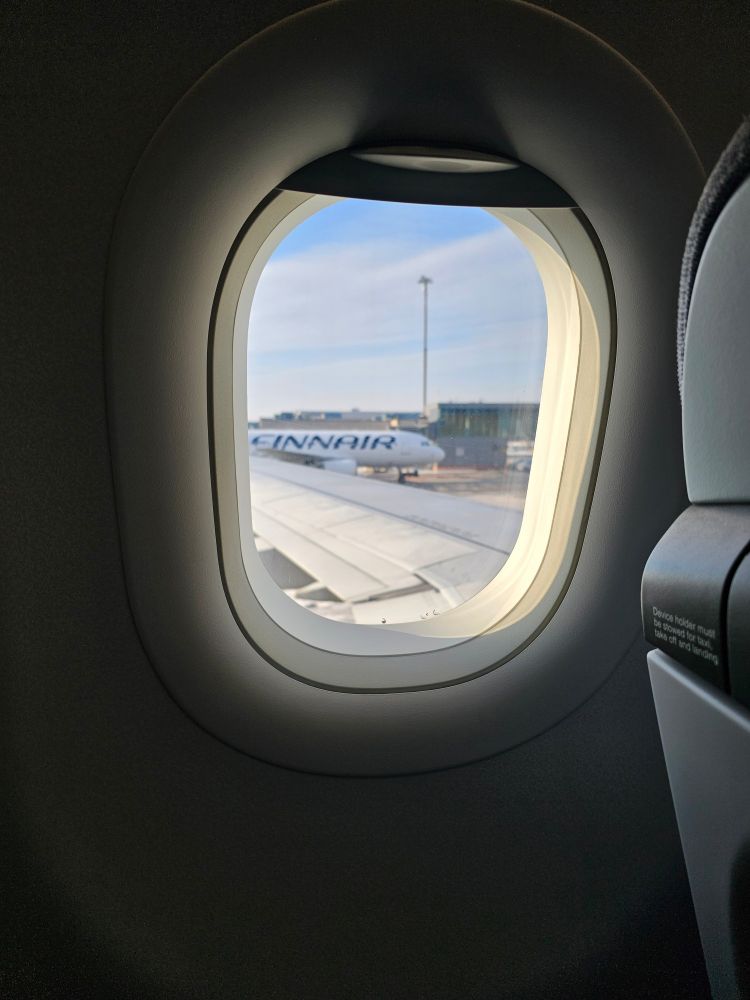 A photo of a Finnair plane taken through another plane's window. 