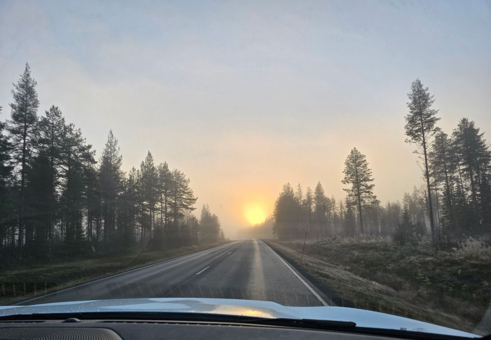 Sunset in the fog through the car windscreen.