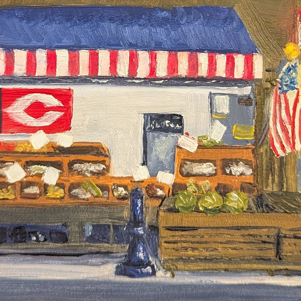 an outdoor produce stand, with fill produce bins, traffic bollard, and framed by flags