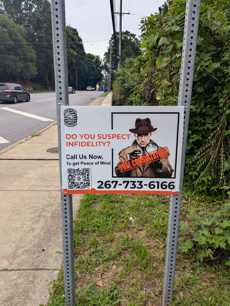 sign by the side of the road that reads "do you suspect infidelity?" and has an old timey private eye guy
