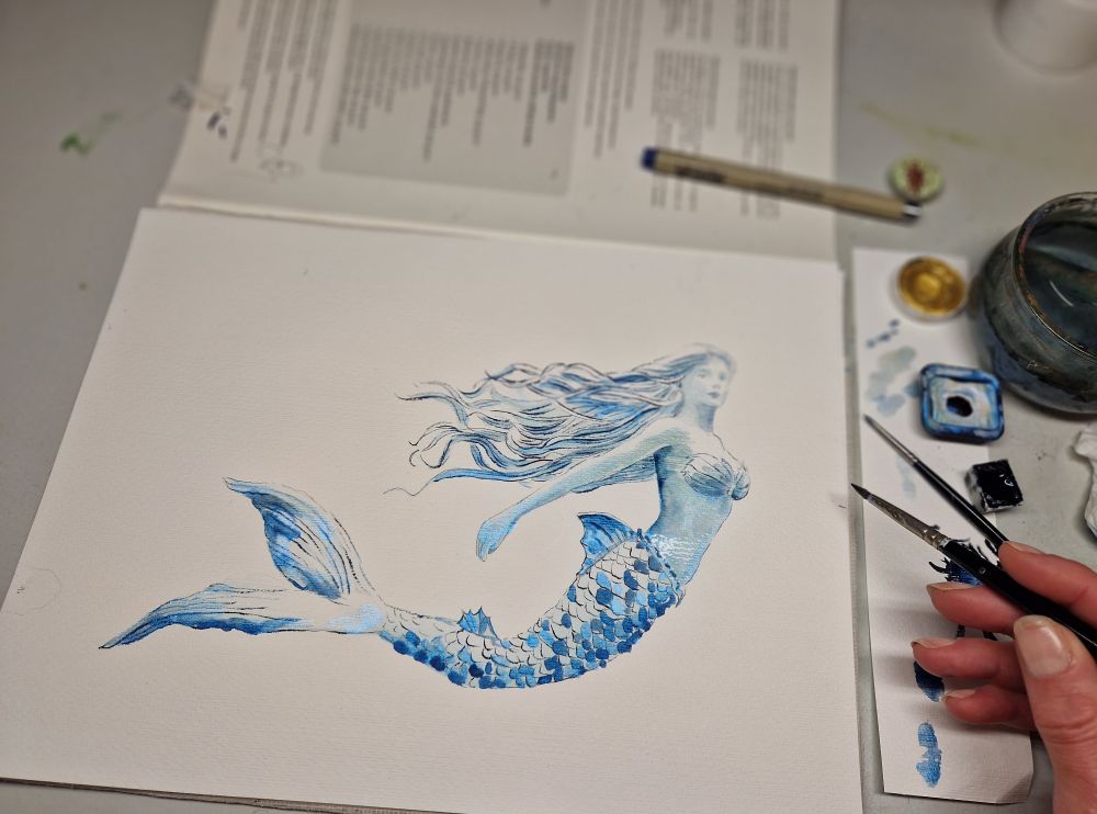 Male eine Meerjungfrau in Aquarellfarbe in blau und Silber 