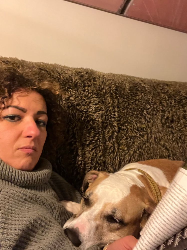 Image of Middle Ages female reading a magazine with an 80 lbs dog laying on her lap
