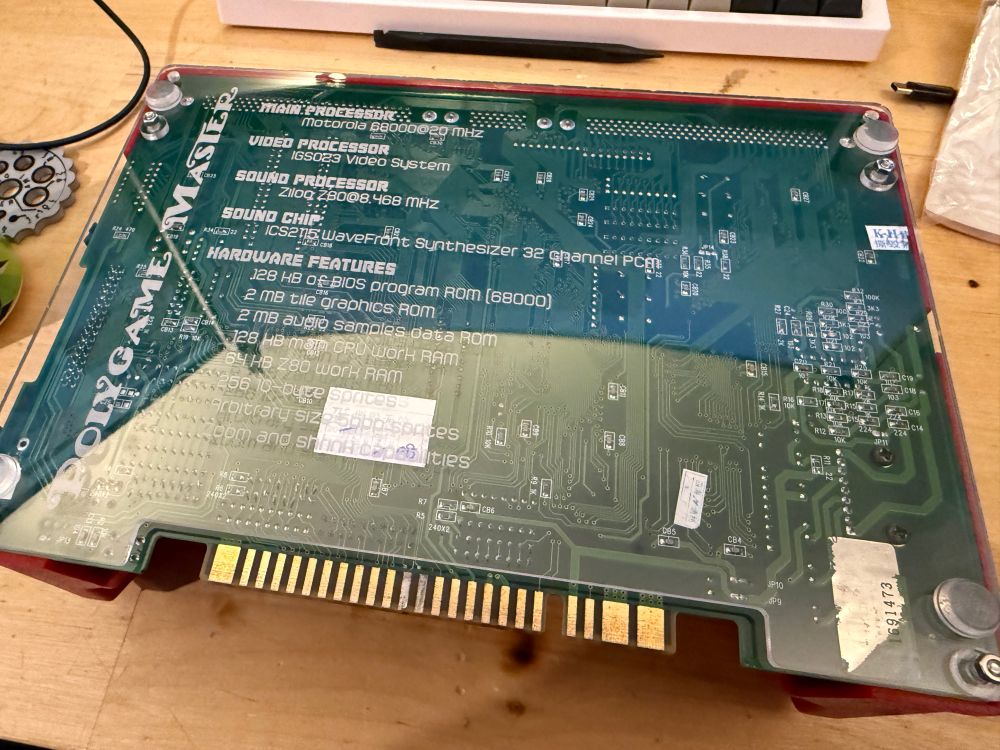 Underside of an IGS PGM arcade board with a custom laser cutter acrylic plate. 