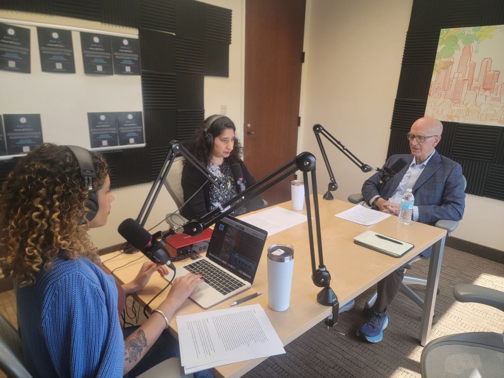 Two women and one man talking into mics