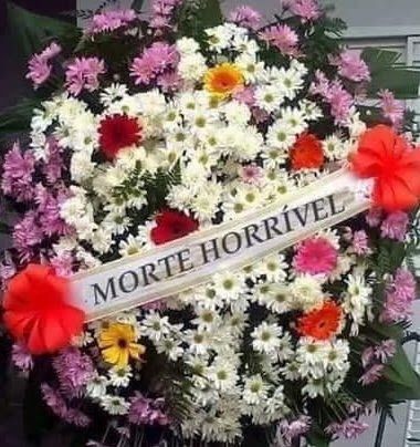 uma grande coroa de flores com uma faixa escrita morte horrível 