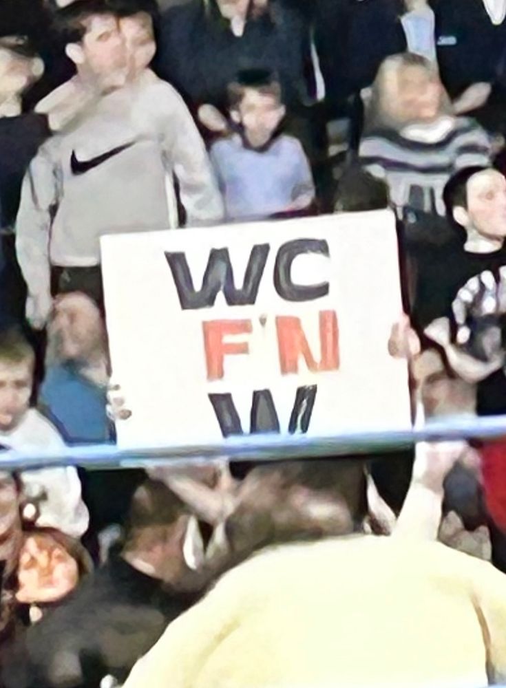 A WCW fan holding a sign that says “WC F’n W”