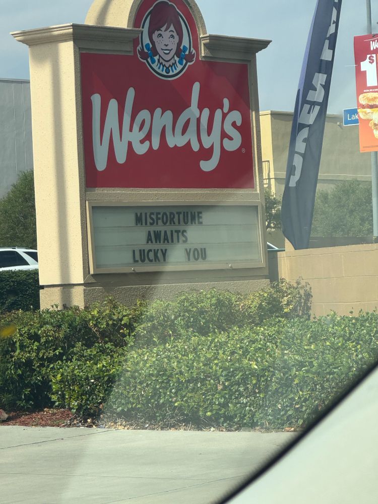 sign at wendys that says: MISFORTUNE AWAITS LUCKY YOU