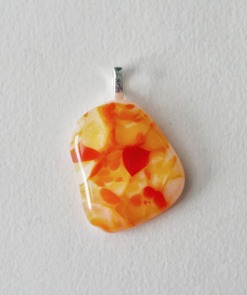 a very bright orange and yellow pendant in an organic free form blob shape