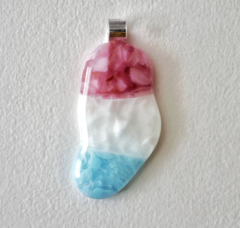 trans pride color blob shaped pendant with a cute little scroll style loop at the top