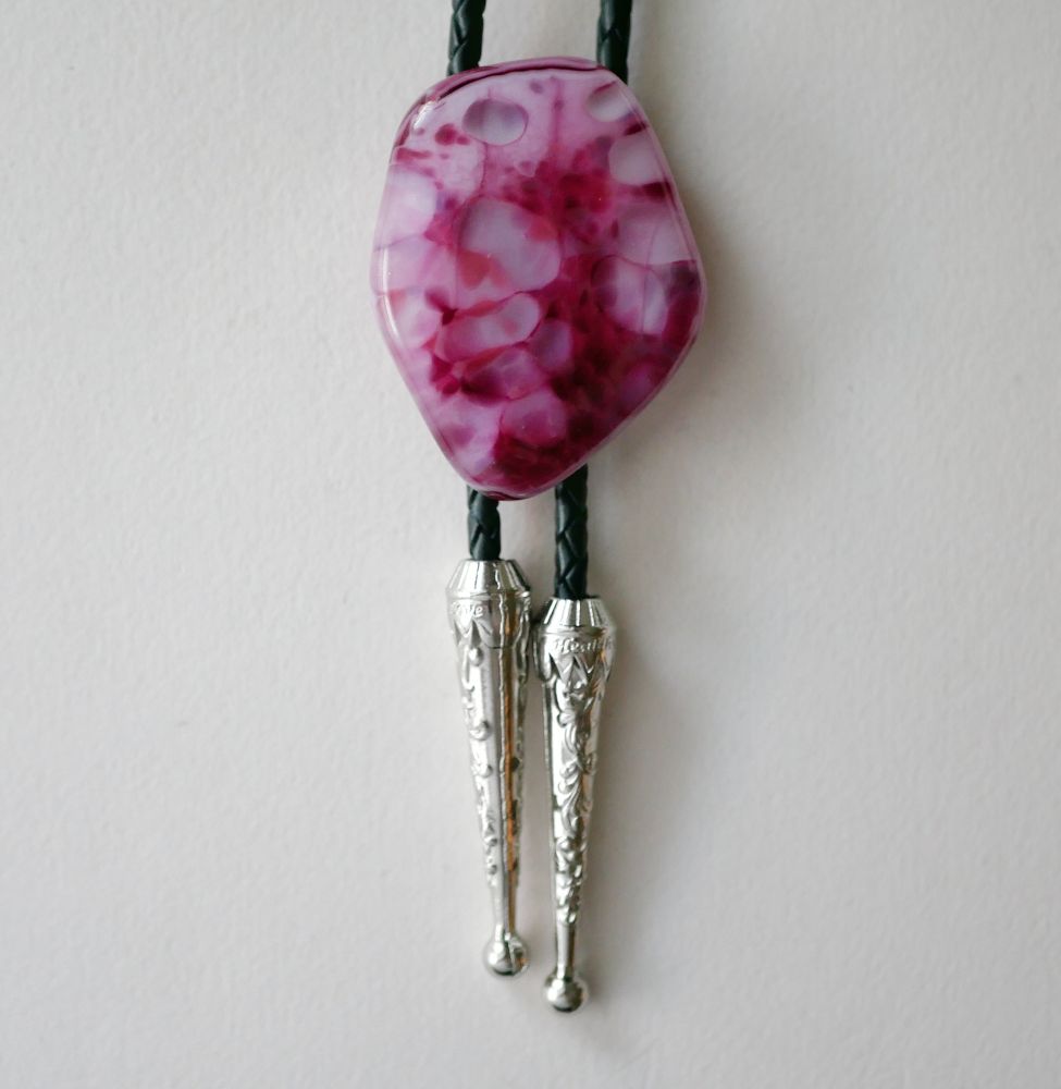 pink speckled bolo tie in a sort of rounded irregular pentagon shape