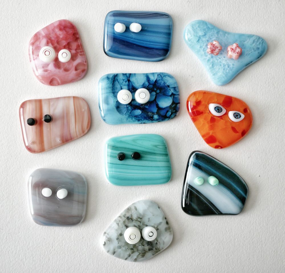 a variety of glass cabochons with goofy three dimensional eyes sticking out. they are very expressive and strange 