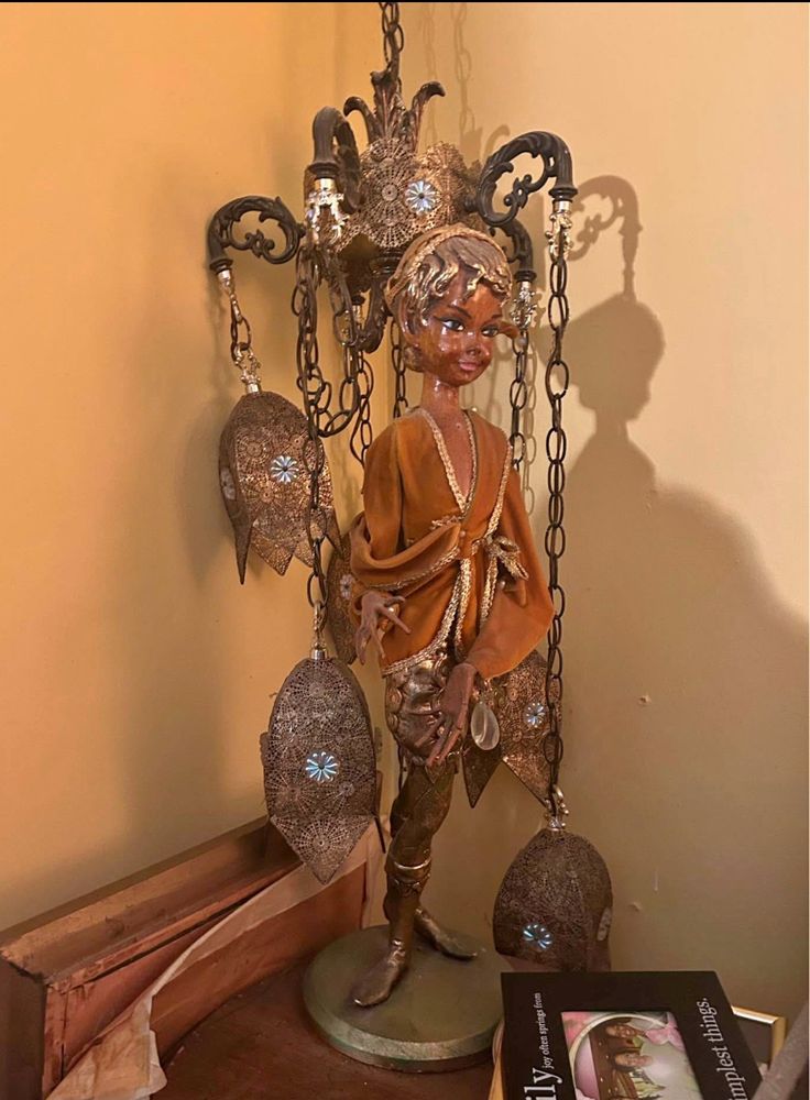 Tall, midcentury lamp featuring an elf carved from wood—the light fixture is comprised of several arabesque lanterns cascading from behind the elf. 