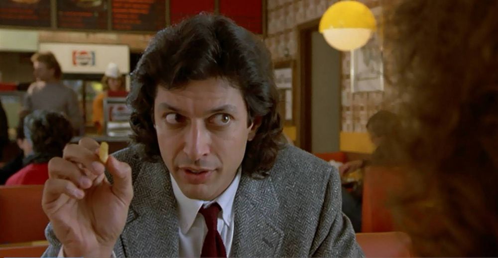 Jeff Goldblum making a salient point to Gina Davis while holding a French fry, in David Cronenberg’s The Fly