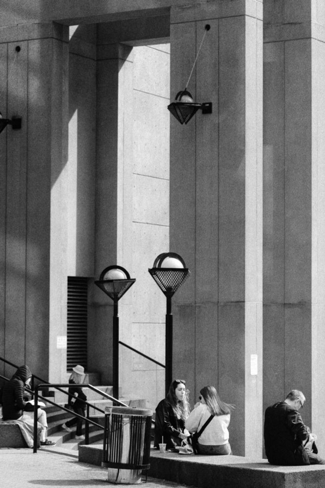 People mill about and chat on the steps at the Vancouver Public Library.