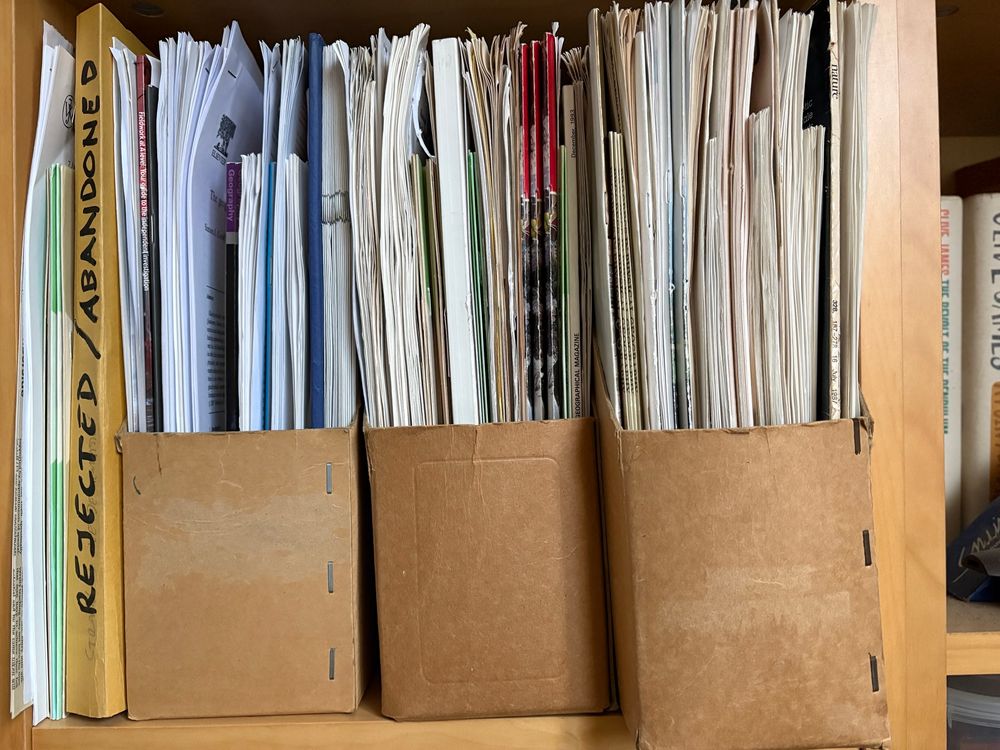 Photo of documents and document wallets on a shelf. One folder is labelled “REJECTED/ABANDONED 