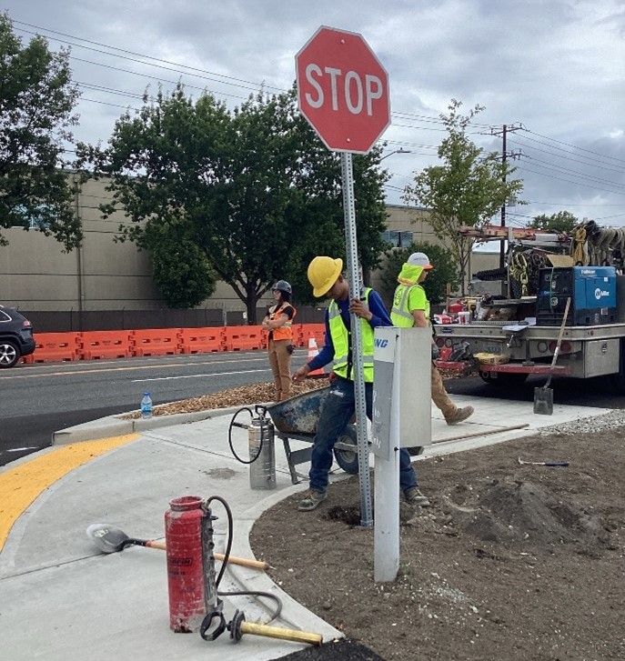 Crews installing signage on E Marginal Way S.