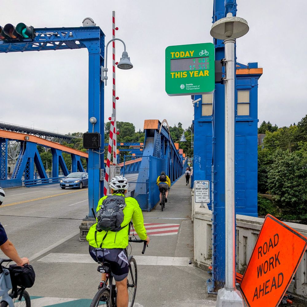 Several people bike across the Fremont Bridge next to the counter.