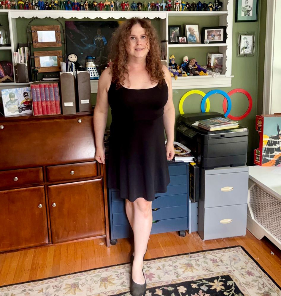 Jadzia is wearing a sleeveless black dress and black Sketchers baller flats.
