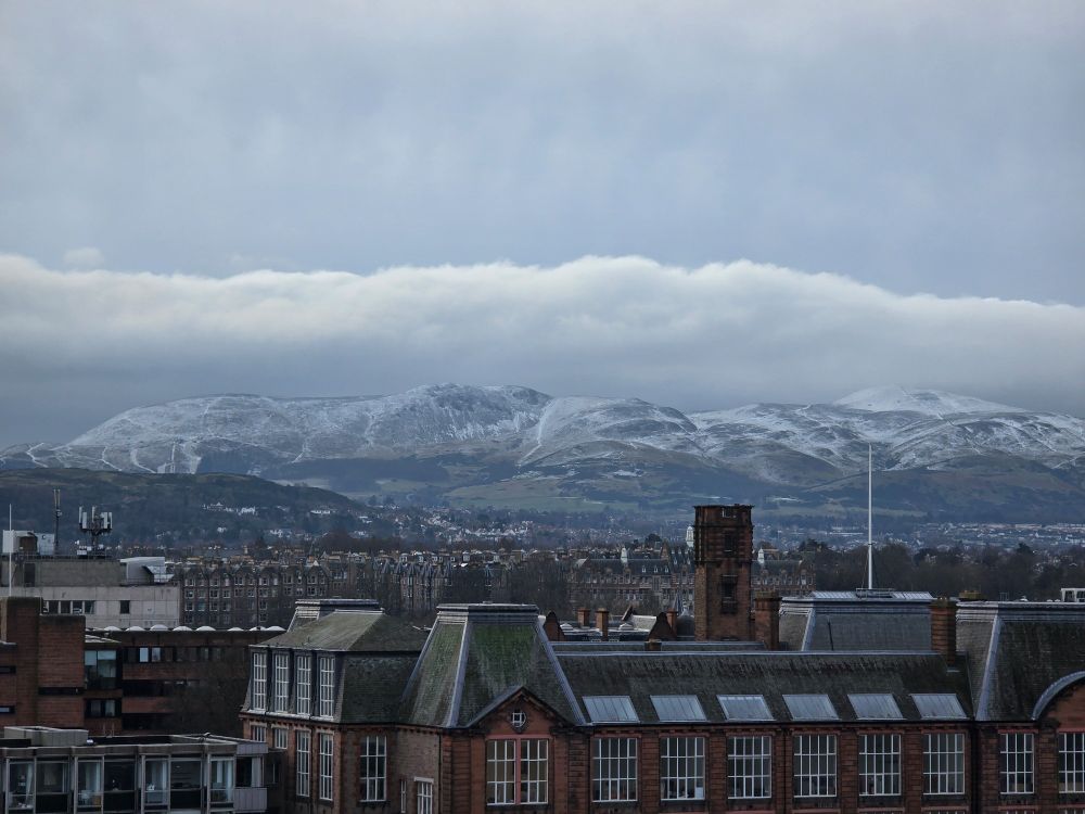 The Pentland Hills as seen from the edinburgh castle esplanade in the distance. Covered in snow. Looking pretty.