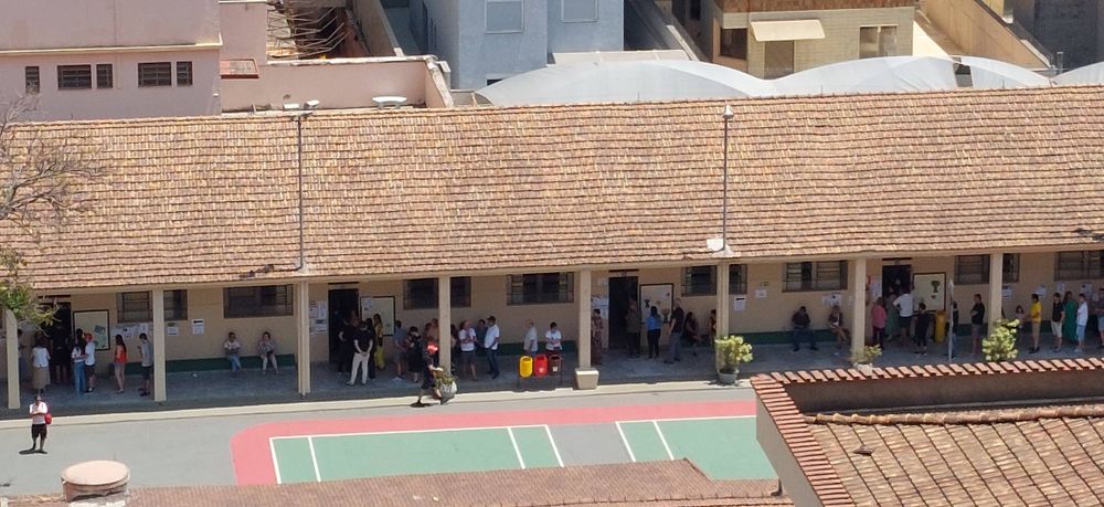 escola em dia de eleições com filas em frente às seções