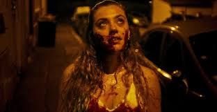 Laurie Pavy in MadS, a blonde covered in blood staring up at a streetlight
