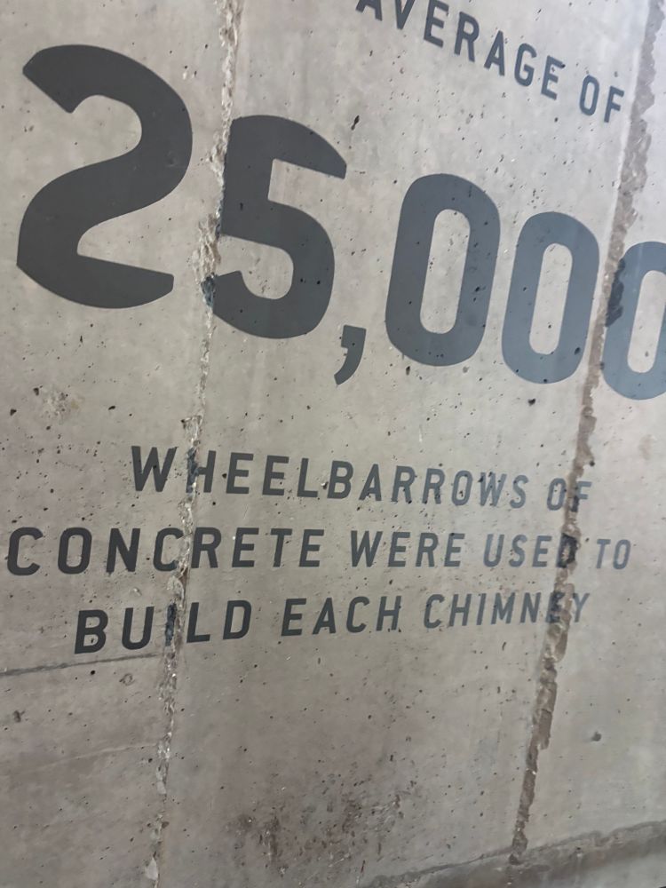 A concrete wall with the text 25,000 wheelbarrows of concrete were used to build each chimney (Battersea Power Station)