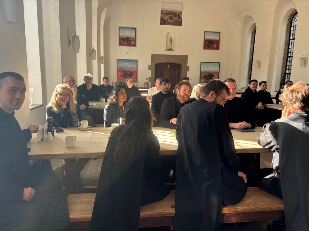 A mixed group of happy students listening.