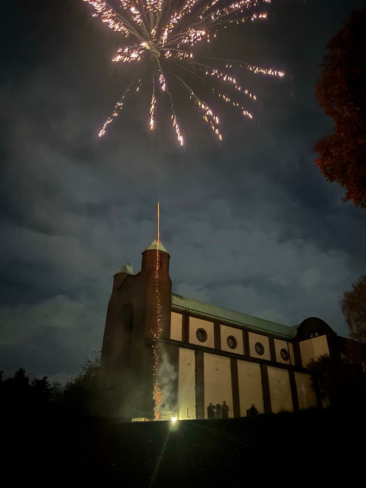 A firework bursts over a large church.