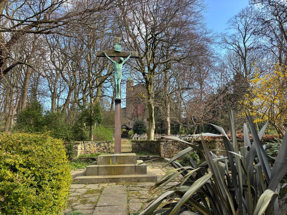 A large crucifix in a spring garden.