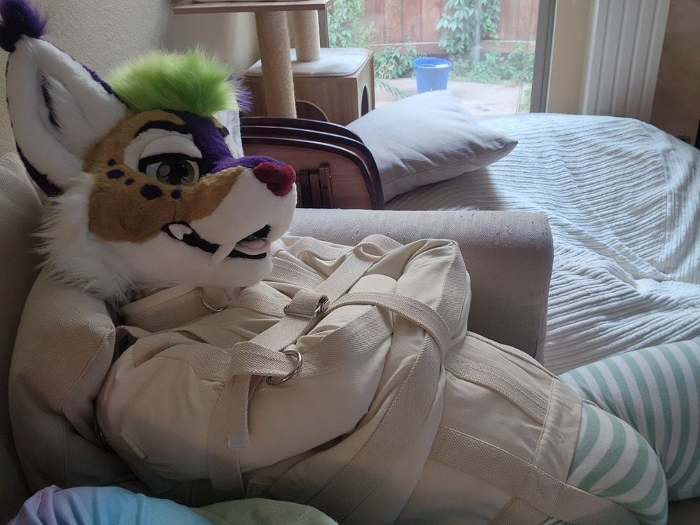 laying on the couch in my fursuit head, straitjacket, footie pj's, and padding