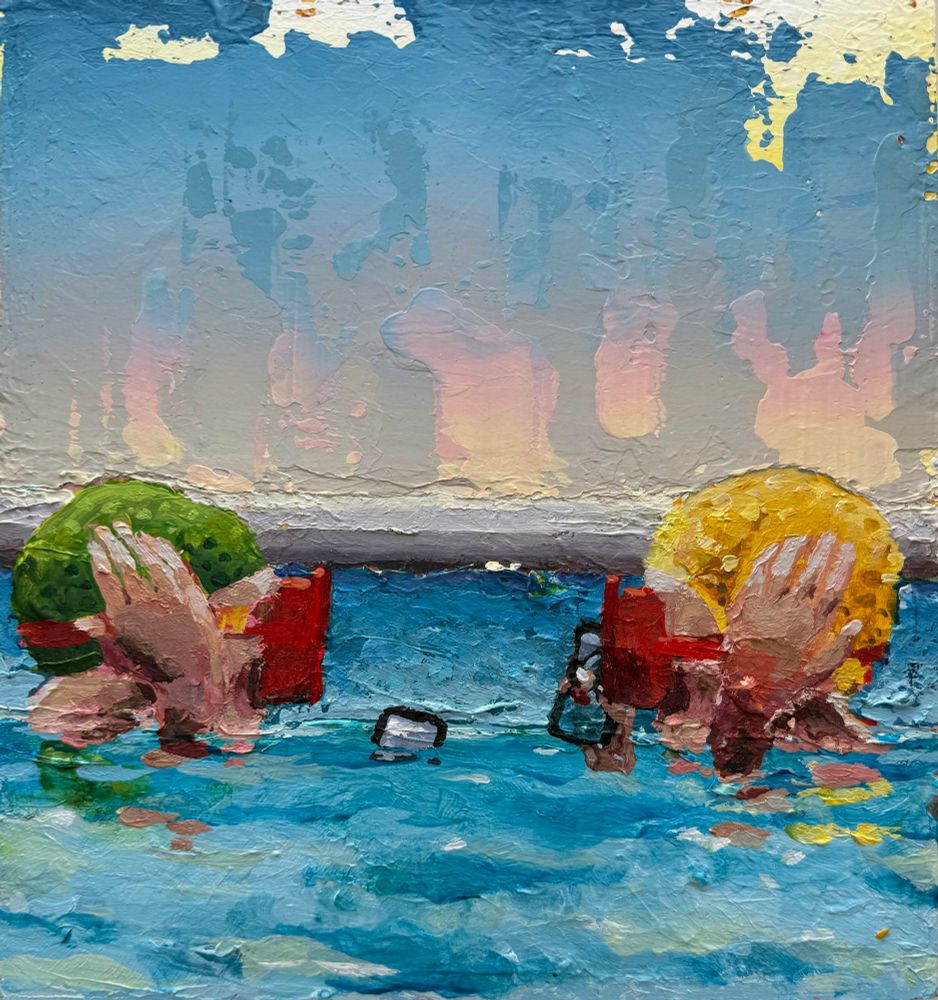 Two heads in green and yellow bathing caps and red diving masks engage in communication with their lips at water level in a swimming pool. Phones are somehow involved.