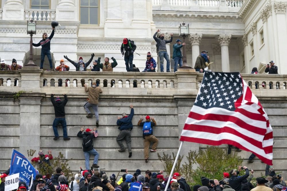 The riot at the Capitol, 6th January 2021 - a US flag is prominent in the bottom right quadrant. 

In the bottom left you can see a blue flag - visible is half the name of a convicted felon who lost an election two months earlier.