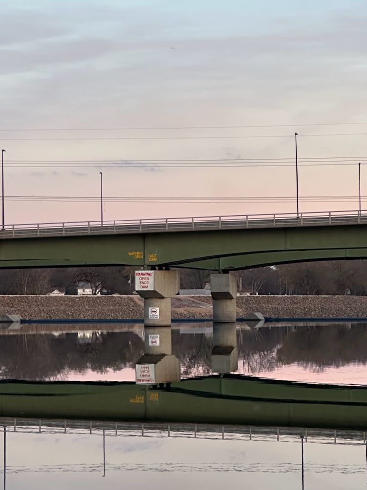 Bridge over the Kaw River reflected in the still water. 