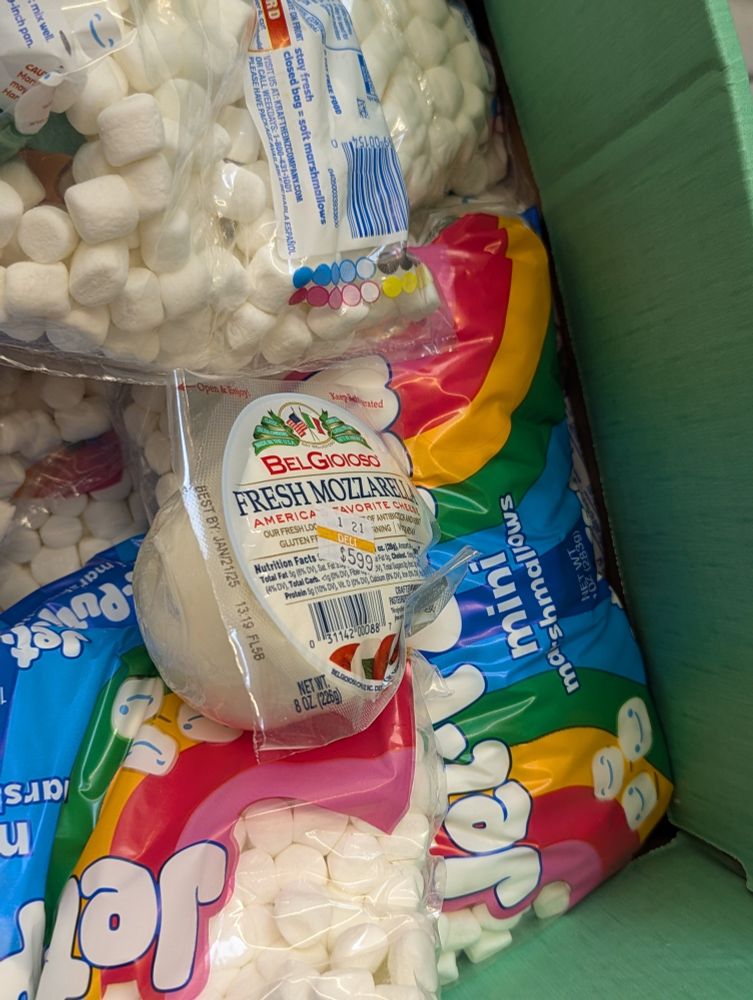 Close up of Supermarket display of jet puffed marshmallows with a package of fresh mozzarella blending in.