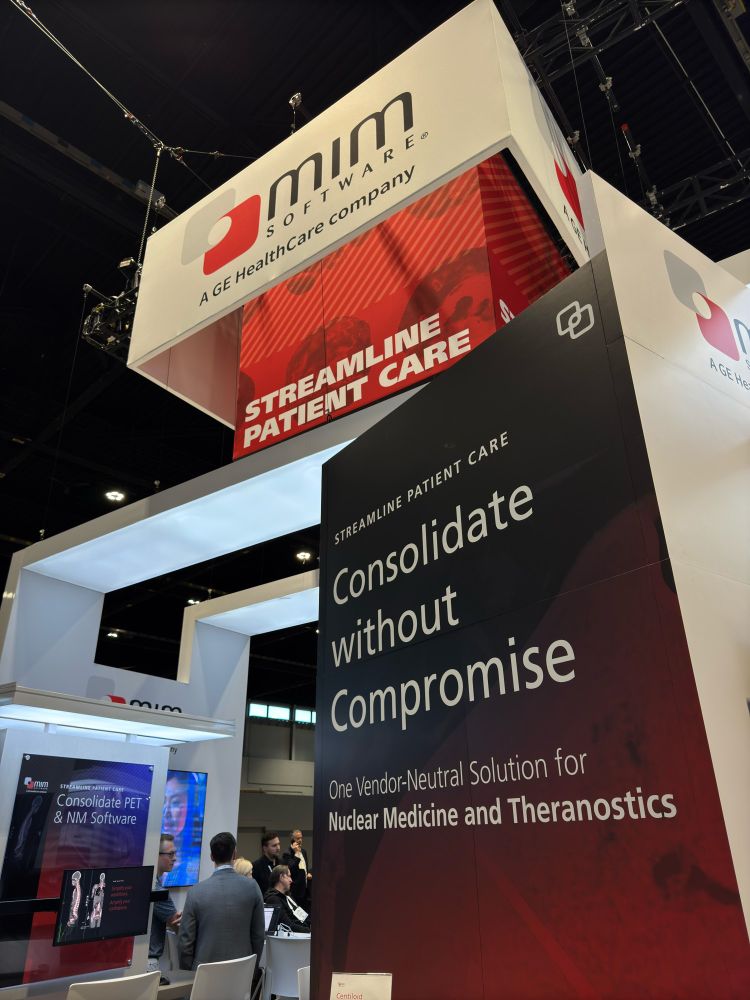 MIM Software booth at RSNA 2024. Booth signs are visible that read "MIM Software, a GE HealthCare company," "Consolidate without Compromise," and "One Vendor-Neutral Solution for Nuclear Medicine and Theranostics"