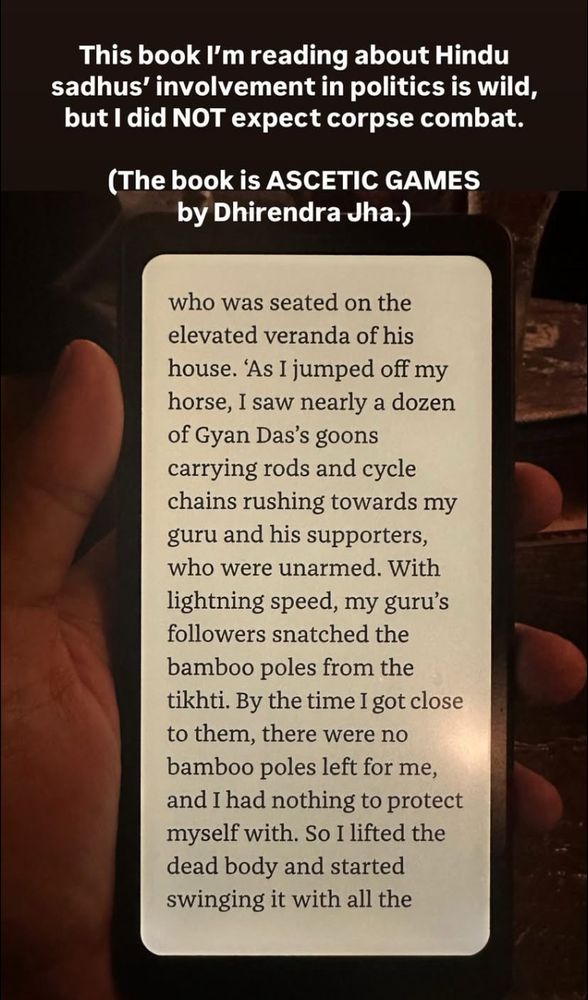 A picture of a hand holding an e-reader. The picture is captioned: This book I'm reading about Hindu sadhus involvement in politics is wild, but I did NOT expect corpse combat.
The passage on the e-reader is a fragment of text that reads as follows: … who was seated on the elevated veranda of his house. As I jumped off my horse, I saw nearly a dozen of Gyan Das's goons carrying rods and cycle chains rushing towards my guru and his supporters, who were unarmed. With lightning speed, my guru's followers snatched the bamboo poles from the tikhti. By the time I got close to them, there were no bamboo poles left for me, and I had nothing to protect myself with. So I lifted the dead body and started swinging it with all the …