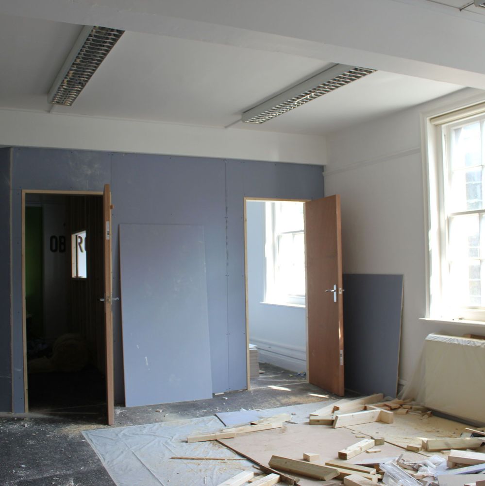 A room undergoing refurbishment with wood off cuts on the floor