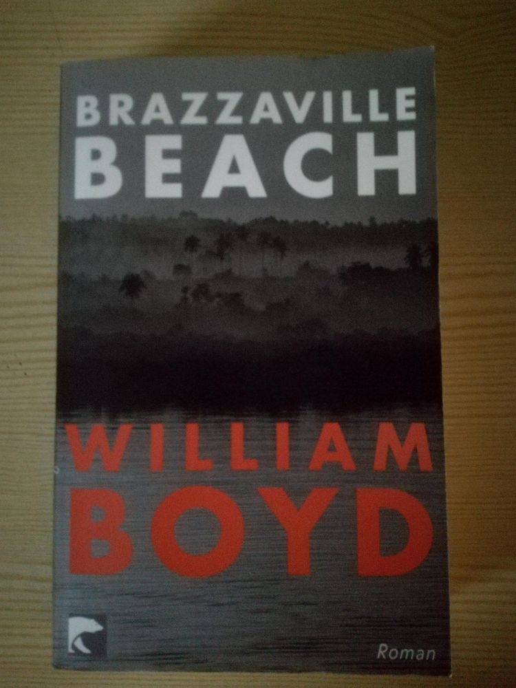 Das Buchcover zeigt den Titel "BRAZZAVILLE BEACH" in weißen, Grioßbuchstaben oben. Darunter eine Landschaft, die einen dichten Wald oder Dschungel andeutet. Im unteren Teil des Covers steht der Name des Autors "WILLIAM BOYD" in großen, roten Buchstaben. 